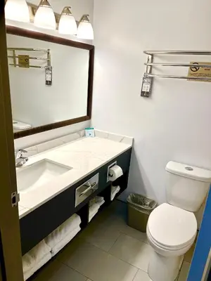 a bathroom with a sink and a toilet and a mirror at Super 8 by Wyndham Hinton-Free Breakfast,Wifi,Parking in Hinton