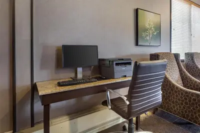 a desk with a computer and a monitor and a chair at Best Western Wayside Inn in Wetaskiwin
