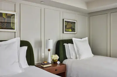 two beds in a hotel room with white pillows at Rosewood Hotel Georgia in Vancouver