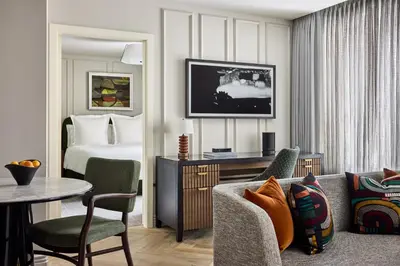a hotel room with a bed and a living room at Rosewood Hotel Georgia in Vancouver