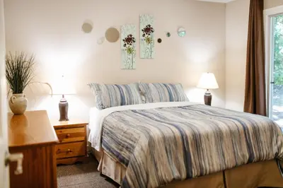 a bedroom with a bed and two lamps and a window at Beach Acres Resort in Parksville