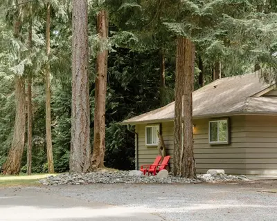 a house with a red chair in front of it at Beach Acres Resort in Parksville