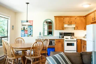a kitchen and dining room with a table and chairs at Beach Acres Resort in Parksville