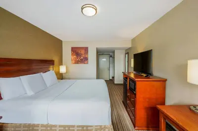 a hotel room with a bed and a flat screen tv at Days Inn by Wyndham Terrace in Terrace