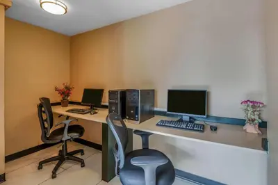 an office with two computers on a desk with two chairs at Days Inn by Wyndham Terrace in Terrace