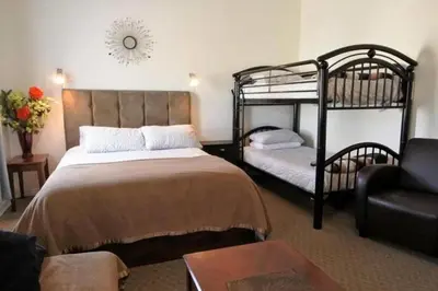 a bedroom with two bunk beds and a couch at Black Rooster Guesthouse in Prince Rupert