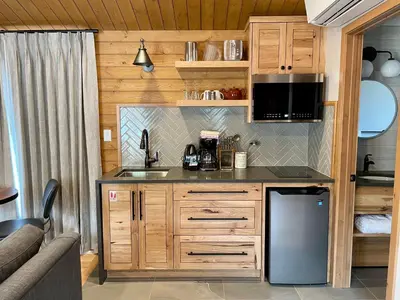 a kitchen with wooden cabinets and a sink and a microwave at Bear Hill Lodge in Jasper