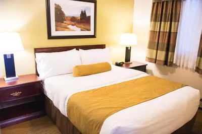 a bed in a hotel room with two nightstands and two lamps at Days Inn by Wyndham High Level in High Level