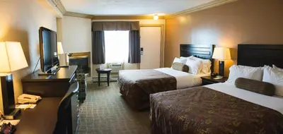 a hotel room with two beds and a television at Days Inn by Wyndham High Level in High Level
