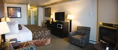 a hotel room with a bed and a flat screen tv at Days Inn by Wyndham High Level in High Level