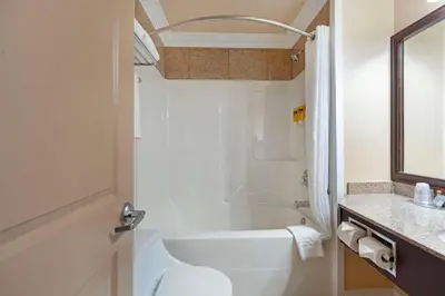 a white bathroom with a tub and a sink at Best Western PLUS Mirage Hotel and Resort in High Level