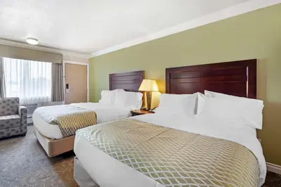a hotel room with two beds and a chair at Best Western PLUS Mirage Hotel and Resort in High Level