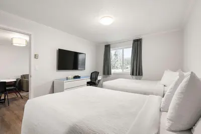 a hotel room with two beds and a flat screen tv at SureStay Hotel by Best Western Rossland Red Mountain in Rossland