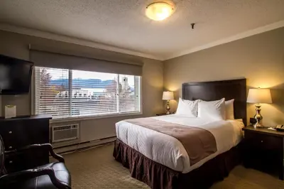 a hotel room with a bed and a large window at Regent Hotel Revelstoke in Revelstoke