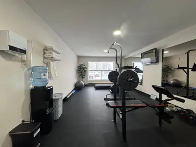 a room with a gym with a treadmill and weights at Howard Johnson by Wyndham Fort St. John in Fort Saint John