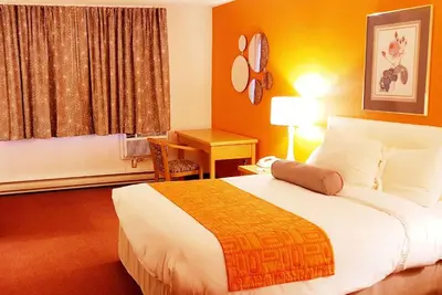 a hotel room with a large bed and a desk at Howard Johnson by Wyndham Fort St. John in Fort Saint John