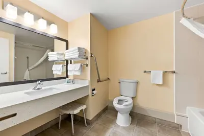 a bathroom with a toilet and a sink and a mirror at Best Western of Olds in Olds