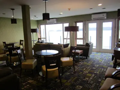 a lobby with couches and tables and chairs at Inn on the Harbour in Prince Rupert
