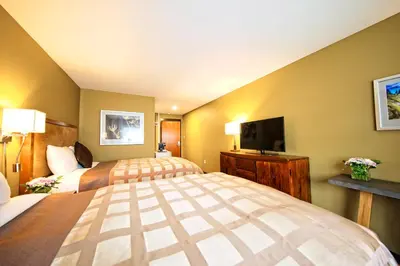 a hotel room with two beds and a flat screen tv at Inn on the Harbour in Prince Rupert