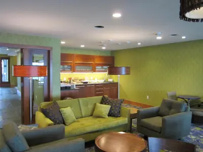 a living room with a couch and chairs and a kitchen at Inn on the Harbour in Prince Rupert