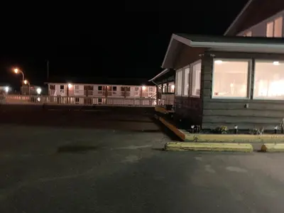 a building with a parking lot at night at Airways Motel in Cold Lake