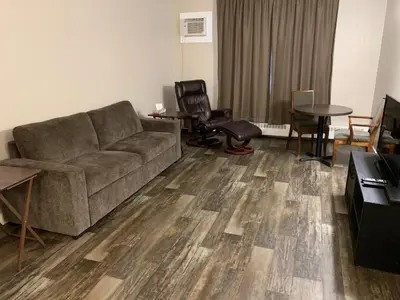 a living room with a couch and a table and chairs at Airways Motel in Cold Lake