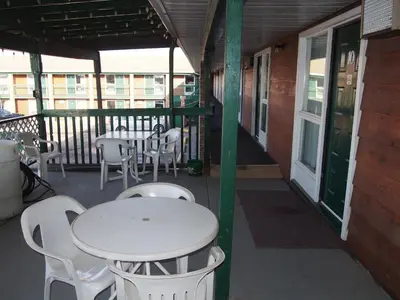 a porch with a white table and chairs on a balcony at Airways Motel in Cold Lake