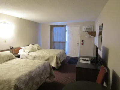 a hotel room with two beds and a television at Airways Motel in Cold Lake
