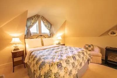 a bedroom with a large bed and a window at Amethyst Inn in Victoria