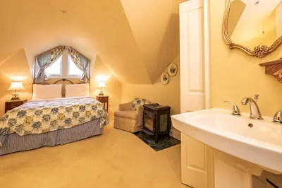 a bathroom with a bed and a sink in a room at Amethyst Inn in Victoria