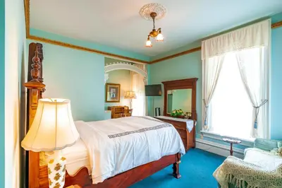 a bedroom with a bed and a large window at Amethyst Inn in Victoria