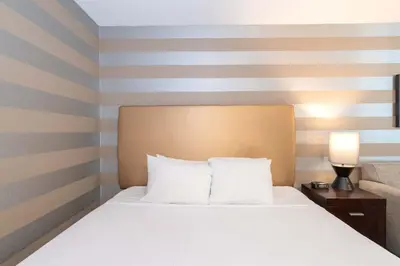 a bed in a hotel room with a striped wall at Sandman Hotel Penticton in Penticton