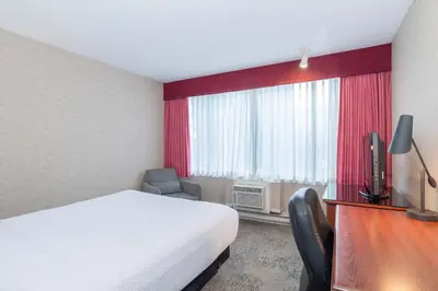 a hotel room with a bed and a window at Sandman Hotel Penticton in Penticton