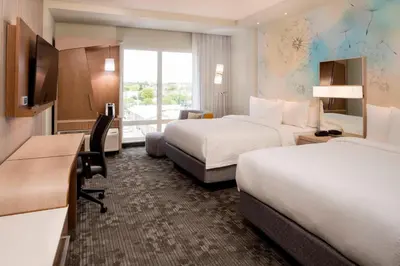 a hotel room with two beds and a desk at Courtyard by Marriott Prince George in Prince George