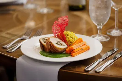 a plate of food with meat and vegetables on a table at Courtyard by Marriott Prince George in Prince George