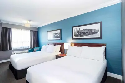 two beds in a hotel room with blue walls at Sandman Hotel & Suites Prince George in Prince George