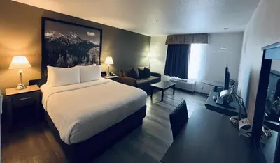 a hotel room with a bed and a couch at Super 8 by Wyndham Dawson Creek in Dawson Creek