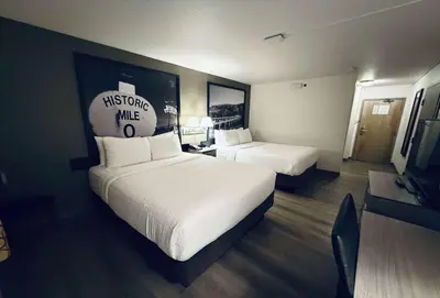 a hotel room with two beds and a tv at Super 8 by Wyndham Dawson Creek in Dawson Creek