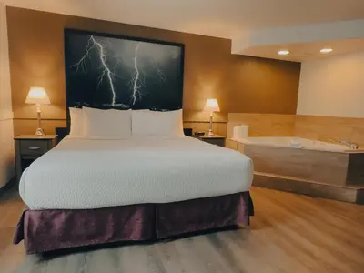 a bedroom with a bed and a bath tub at Super 8 by Wyndham Dawson Creek in Dawson Creek