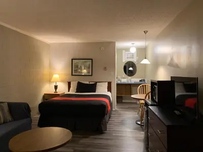 a hotel room with a bed and a couch at Motel Bavaria in Radium Hot Springs