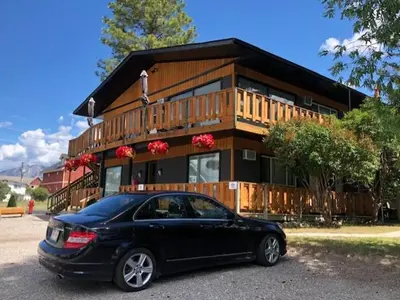 a black car parked in front of a house at Piccadilly Motel in Radium Hot Springs