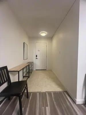 a hallway with a table and a chair and a door at Crystal Springs Lodge in Radium Hot Springs