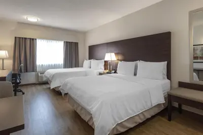a hotel room with two beds and a window at Best Western Dawson Creek in Dawson Creek
