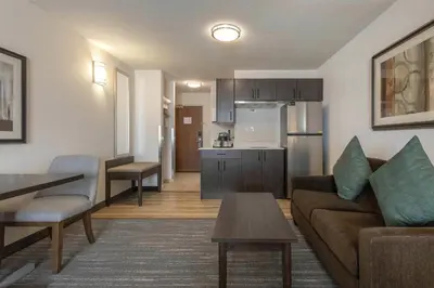 a living room with a couch and a table and a kitchen at Best Western Dawson Creek in Dawson Creek