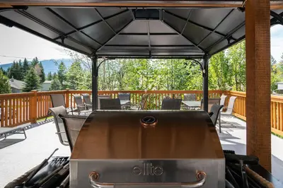 a barbecue under a black cover on a deck at Cedar Motel in Radium Hot Springs