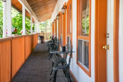 an empty porch with tables and chairs on a building at Cedar Motel in Radium Hot Springs