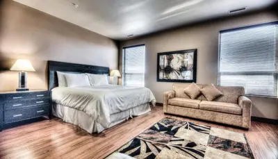a bedroom with a bed and a couch at Grand Inn & Residence- Grande Prairie in Grande Prairie
