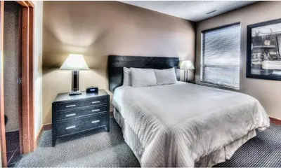 a bedroom with a large bed and a window at Grand Inn & Residence- Grande Prairie in Grande Prairie