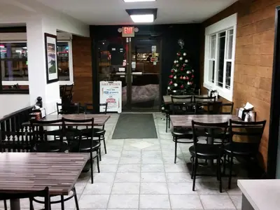 a christmas tree in a restaurant with tables and chairs at Wild Rose Country Inn in Grande Prairie
