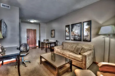 a living room with a couch and a table at Podollan Inn & Spa - Grande Prairie in Grande Prairie